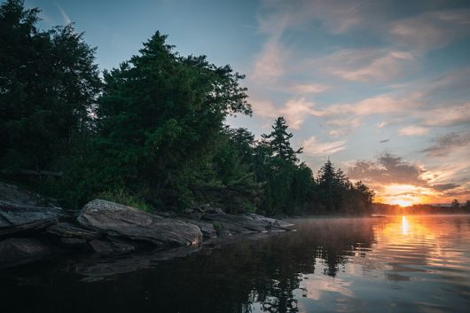 Sunrise over a lake by Derek Sutton